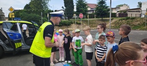 widzimy policjanta z odwiedzającymi stanowisko dziećmi.