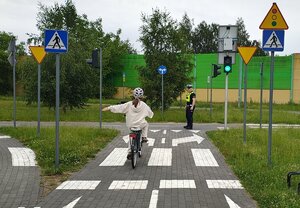 widzimy uczestnika jadącego rowerem na miasteczku ruchu drogowego.