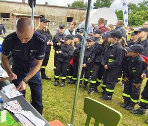 widzimy stoisko profilaktyczne policjantów oraz dzieci z opiekunami.