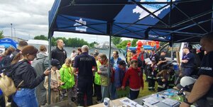 widzimy stoisko profilaktyczne policjantów oraz dzieci z opiekunami.