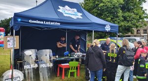 widzimy stoisko profilaktyczne policjantów oraz dzieci z opiekunami.