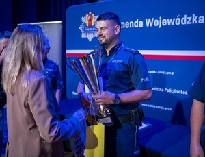 policjantowi kobieta składa gratulację.