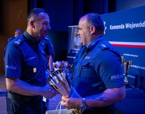 Komendant składa gratulacje policjantowi.
