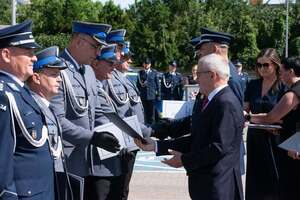 widzimy szereg policjantów oraz Starostę i komendantów wręczających odznaczenia policjantom.