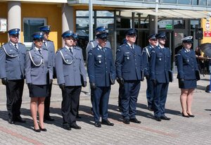 widzimy szereg policjantów stojących na tle budynku komendy.