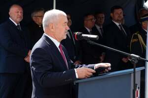 widzimy przemawiającego Starostę Wieruszowskiego stojącego przy ambonie a pod namiotem stoją zaproszeni goście.