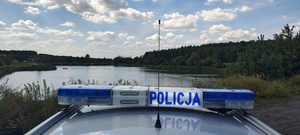na zdjęciu widnieje logo policja i w tle zbiornik wodny