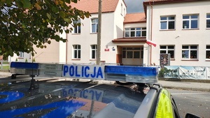 widzimy budynek szkoły oraz belkę od radiowozu.